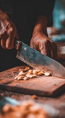 Preparing food on a worn wooden board with a large knife. Aged hands are chopping a pile of ingredients, with a blurred background and warm tones