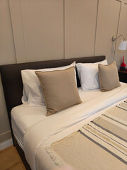 Headboard, warm beige pillows and lamp in the room