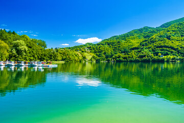 Fototapeta premium Amazing green Lake Plivsko jezero, Jajce, Bosnia and Herzegovina, wood reflection on water surface