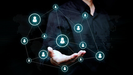  A business professional touches a digital interface with connected user icons over a world map to illustrate recruitment and global collaboration.
