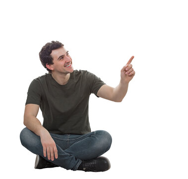 Positive young man sitting on the floor pointing forefinger up smiling with confidence. Solving problem, find solution, business idea and creativity concept. Male isolated on transparent background