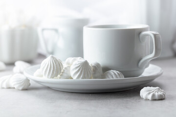 Vanilla meringue and coffee cup on a white marble table.