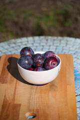 vertical picture of a bowl of plums