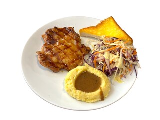 This is a professional, high-angle shot of a plate of grilled chicken steak. The main course consists of a golden-brown chicken thigh with visible grill marks