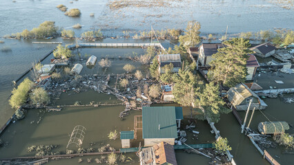 Aerial drone footage showing severe flooding with submerged houses and roads. Wide overhead view of a disaster zone after heavy rainfall, showcasing water damage, extreme weather, and climate-related 