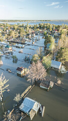 Aerial drone footage showing severe flooding with submerged houses and roads. Wide overhead view of a disaster zone after heavy rainfall, showcasing water damage, extreme weather, and climate-related 