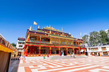 Obraz premium Beautiful and very colourful Monastery of Rabangla - called Ralong Monastery, at Sikkim , India. Red and white check foreground and blue sky in the background. Image shot with permission.