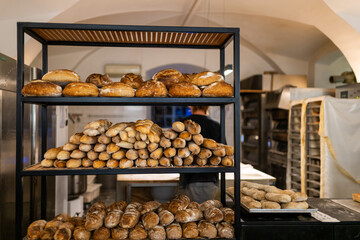 Artisan bakery interior filled with golden rustic loaves and rolls. Freshly baked bread creates a cozy, authentic food scene with copy space for healthy lifestyle concepts.