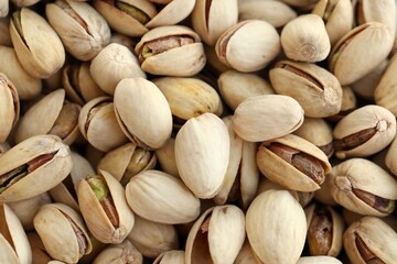 Many tasty unpeeled pistachios top view flat lay background pattern