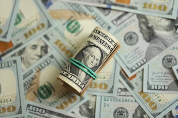 Fototapeta premium Money close up. A roll of one American dollars on 100 USD banknotes