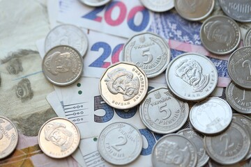 Ukraine money coins lying on mixed hryvnia banknotes. Finance background concept.
