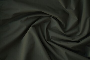 Texture of Dark green military uniform textile cloth with folds