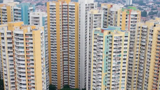 Residential apartment buildings. Colorful walls of a modern high-rise building. Complex of block of flats in the city district. Aerial view. Vertical