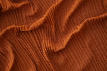 Bright orange fabric background from a piece of crumpled clothes