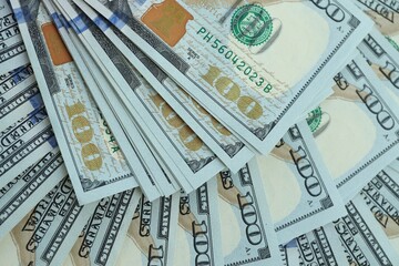 Many hundred dollar bills new banknotes in big pile under the natural light