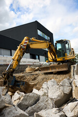 Obraz premium Road repair in urban environment. Repair with large equipment. Repair barriers. Demolition. Excavator work.