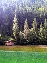 Charming wooden cabin by a green alpine lake in Turnau, Austria. Peaceful forest and crystal-clear water create a perfect nature and travel landscape.