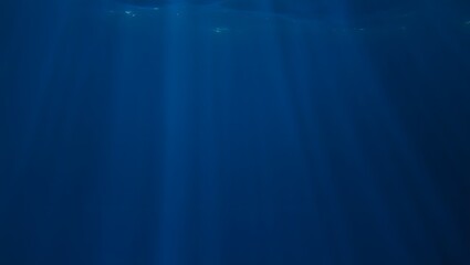 Deep blue underwater scene, sunlight pierces surface, creating an ethereal and tranquil atmosphere, evoking sense of wonder