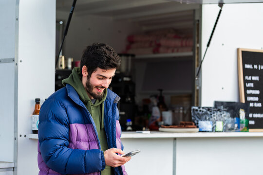 coffee van barista with mobile phone doing social media reels post
