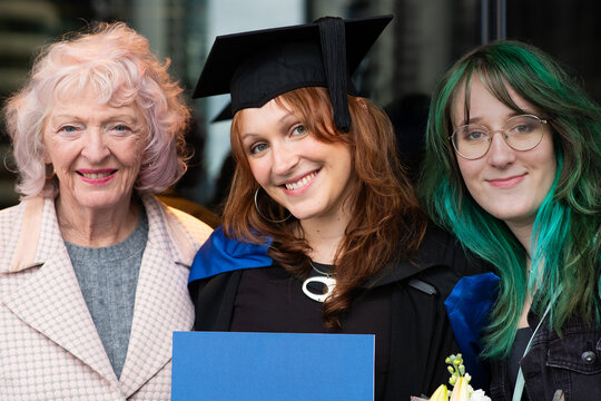 young female student with her family at graduation