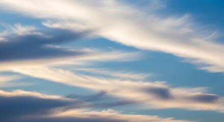 Obraz premium A serene expanse of cerulean sky adorned with dynamic, wispy clouds, creating a captivating and ever-changing atmospheric spectacle