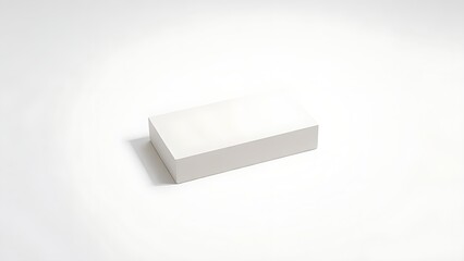Minimalist white rectangular object on pure white surface, showcasing clean modern design.