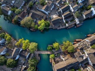 Naklejka premium Aerial view of ancient Chinese water town with traditional houses and bridges along blue-green river in Zhejiang, showcasing Jiangnan's tranquil riverside architecture and greenery.