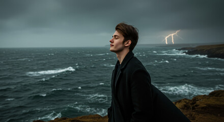 Young man contemplates at sea