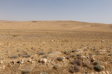 Desert landscape of Kunduz Province in Afghanistan with sparse vegetation under a hot hazy sky