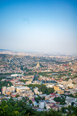 Fototapeta premium A breathtaking panoramic view of Tbilisi, Georgia, showcasing the city’s urban landscape with the golden-domed Holy Trinity Cathedral (Sameba) standing out in the distance