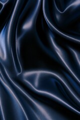Fototapeta premium Dark blue abstract background with wavy folded texture. Flowing fabric with light and shadow for fashion, elegance, and luxury concept.