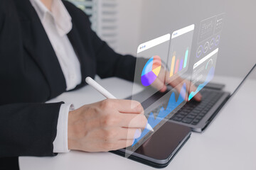 Data analytics concept showing businesswoman using digital pen on tablet with holographic charts, illustrating business intelligence, performance metrics, data visualization, and digital reporting.