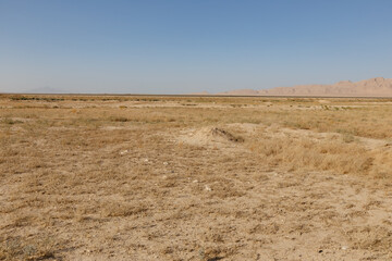 Arid desert landscape in balkh province afghanistan with distant mountains and a clear sky