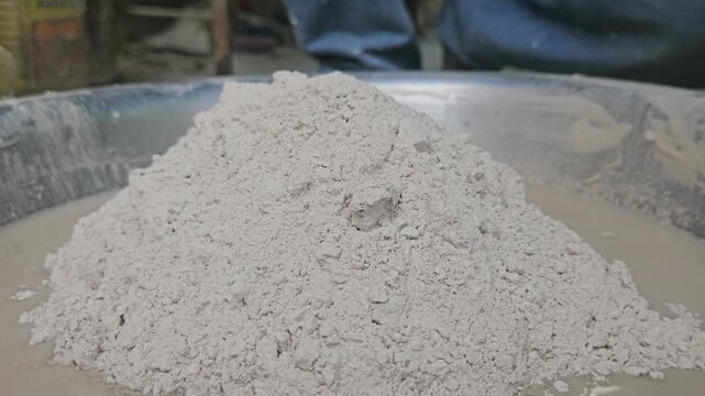 Indian Sculptor artist mixing plaster of paris in water to make sculpture, Odisha, India