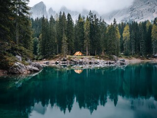 Fototapeta premium Tranquil forest camping by serene lake, surrounded by majestic mountains and lush trees, ideal for nature enthusiasts and adventurers.