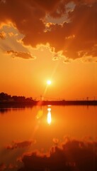 Obraz premium Breathtaking Sunset Over Tranquil Lake with Reflective Waters and Dramatic Cloudscape in Vital Warmth of Golden Hour Evening