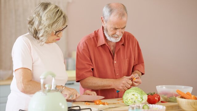 Senior couple preparing vegetables in kitchen: promoting healthy eating and togetherness