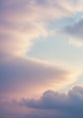 Naklejka premium Evocative sunset sky with soft clouds and gentle color palette