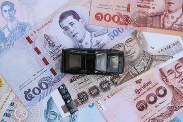 Thai baht currency money bills and toy car. The concept of car ownership