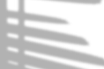 Window with shadow overlay on soft white background, showcasing diagonal light patterns.