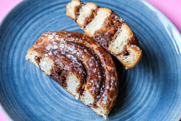 Single Cinnamon Swirl Cut In Half On A Plate