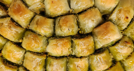 Small pieces of baklava, unique to Gaziantep, Turkey, is a traditional Turkish dessert prepared with very thin layers of phyllo dough and Antep pistachios, with syrup poured over it after it's baked