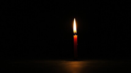 Fototapeta premium A single red candle in the dark.