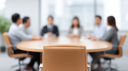 Fototapeta premium Focused Meeting Scene with Blurred Participants at Round Table in Modern Office Setting, Emphasizing Discussion and Collaboration Among Team Members