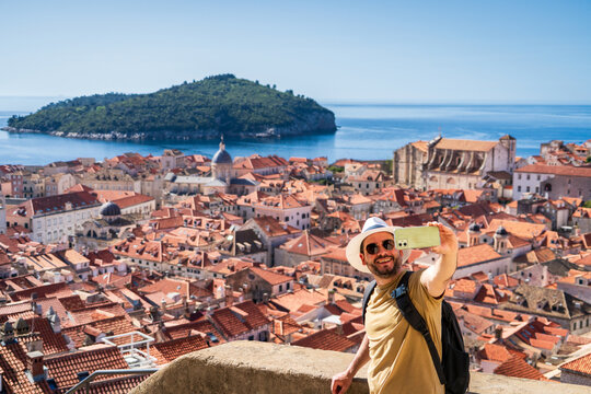 Hombre turista tom&aacute;ndose una selfie desde las murallas de la ciudad de Dubrovnik, en Croacia