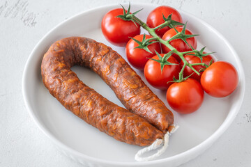 Curved Chorizo and Cherry Tomatoes Arranged Neatly on Minimal White Ceramic Plate