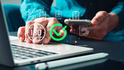 A professional hand interacts with futuristic digital display featuring ISO symbol, checkmark, symbolizing quality management, certification, compliance, standardization, trusted business excellence.