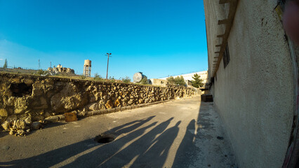Shadows on a Sunny Street with Stone Wall. Syria, Sednaya Prison.