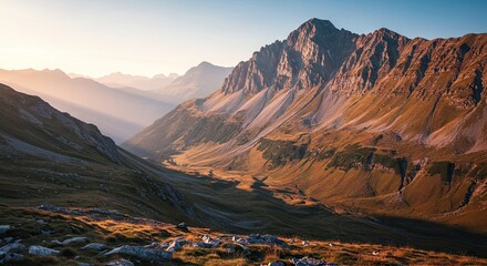 Obraz premium Majestic alpine valley bathed in the ethereal glow of sunrise or sunset, showcasing rugged mountain peaks and a serene natural landscape