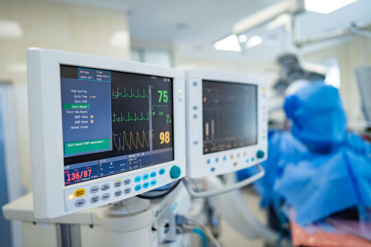 Monitors show patient data. Advanced monitors display vital metrics during surgery, ensuring careful observation in a bright operating room.